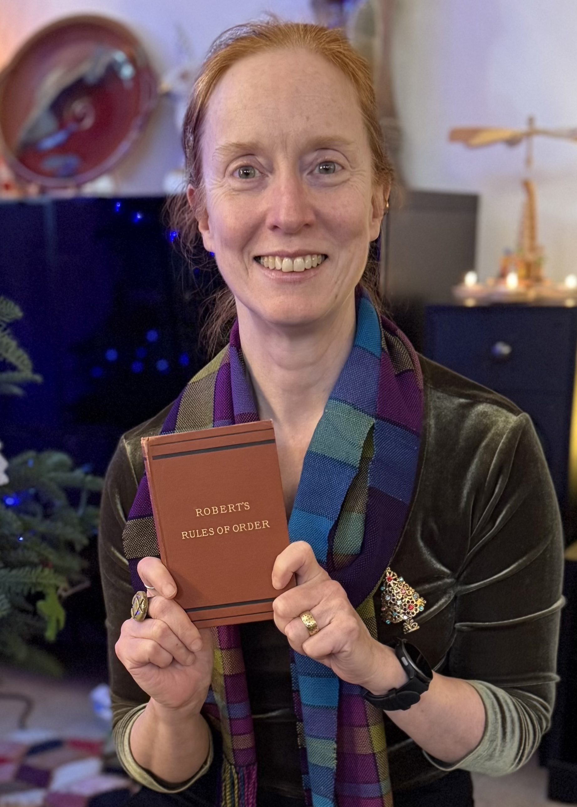 Benita holding an early edition of a Robert's Rule of Order